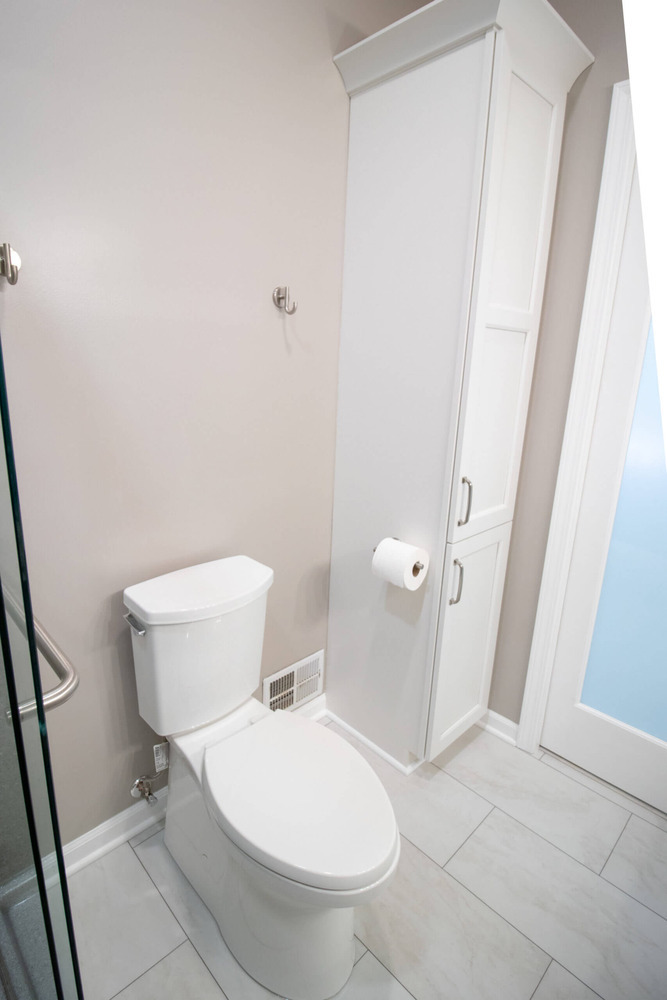 updated bathroom renovation with built-in storage cabinet and tile flooring by Odd Fellows Contracting in Williamston, MI