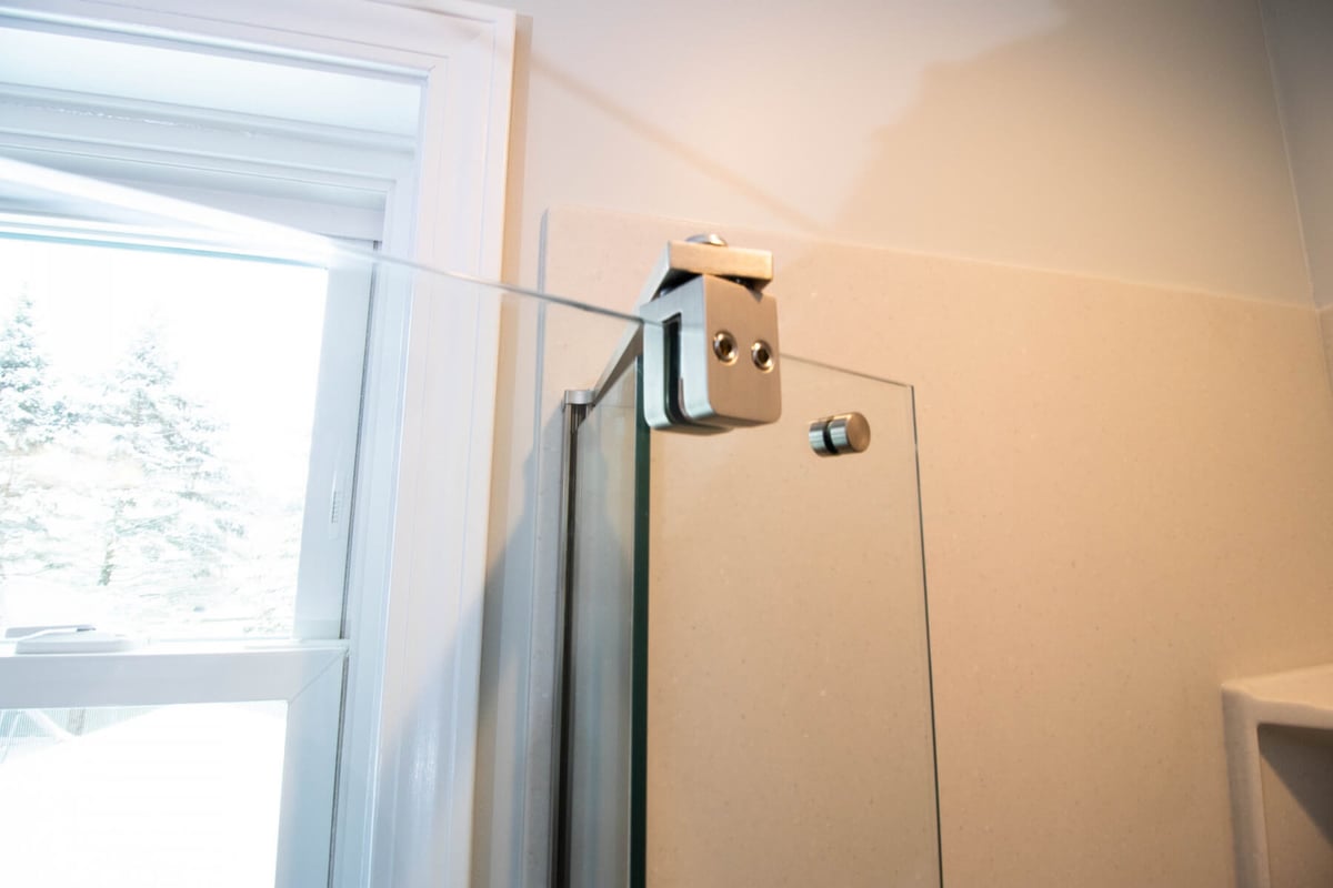 bathroom remodel by Odd Fellows Contracting in Mason MI with glass shower panel hardware detail
