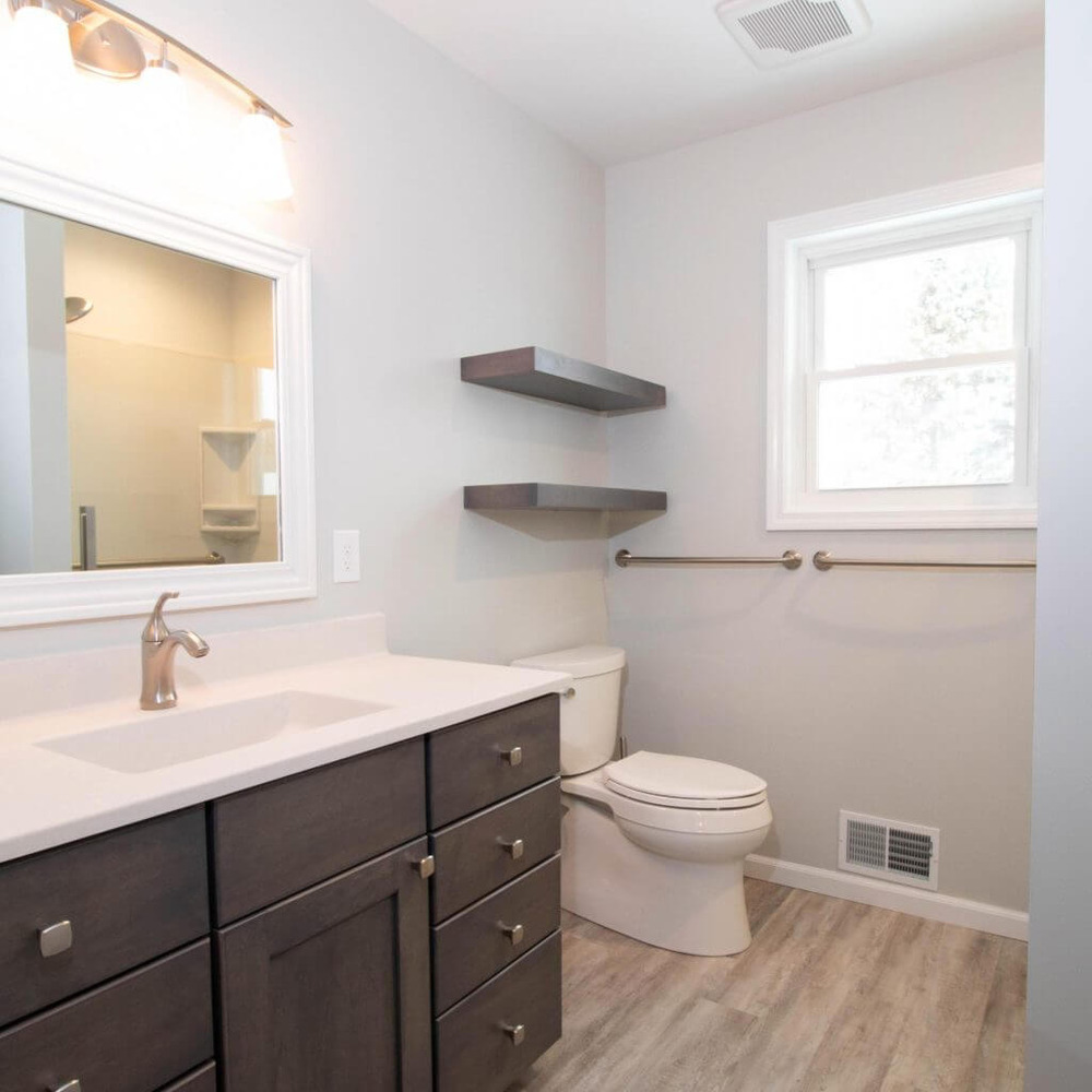 bathroom remodel by Odd Fellows Contracting in Mason MI with modern vanity and floating shelves