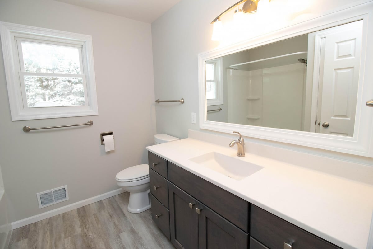 bathroom remodel by Odd Fellows Contracting in Mason MI with modern vanity and large mirror