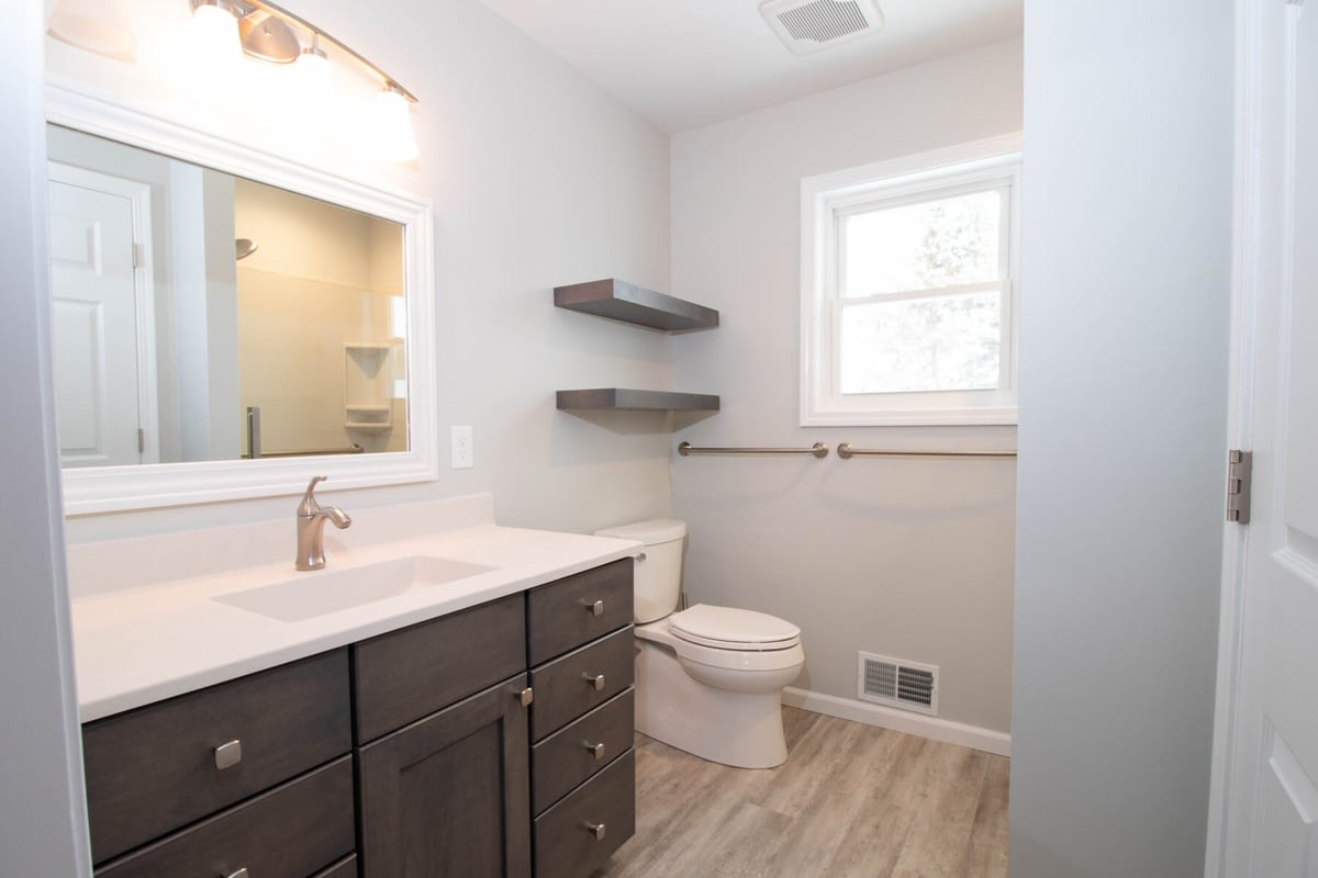 bathroom remodel by Odd Fellows Contracting in Mason MI with new vanity toilet and floating shelves