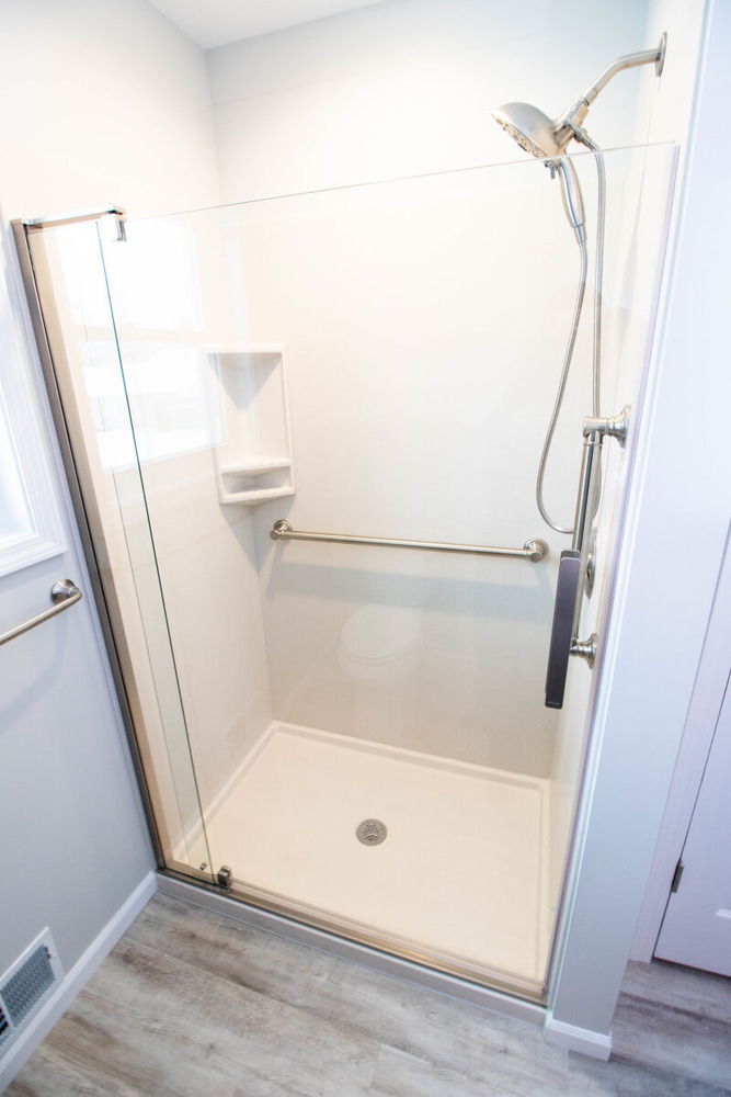 remodeled bathroom by Odd Fellows Contracting in Mason MI with modern glass shower and hardware