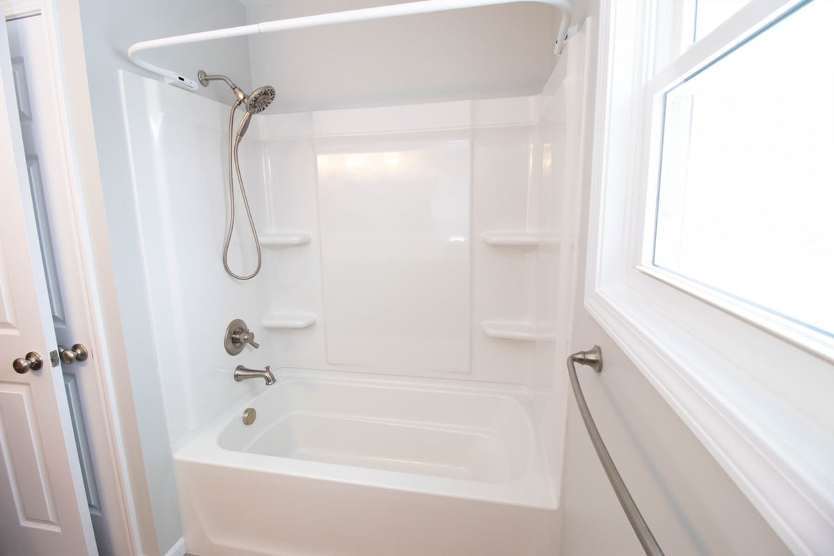 remodeled bathroom by Odd Fellows Contracting in Mason MI with modern tub and wall surround