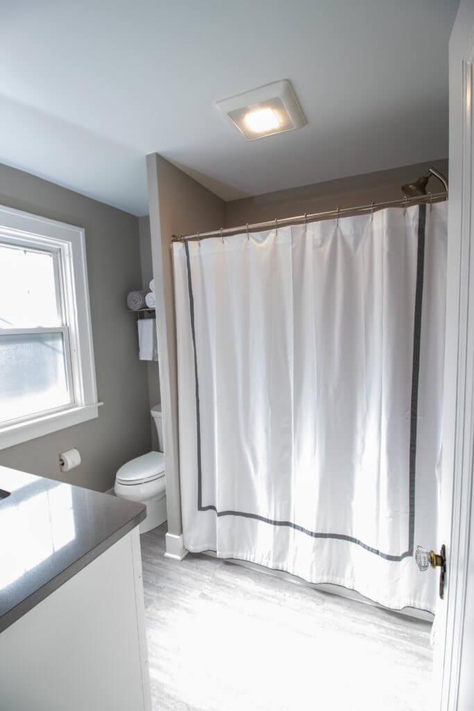 bathroom with shower curtain and vanity by Odd Fellows Contracting in East Lansing MI