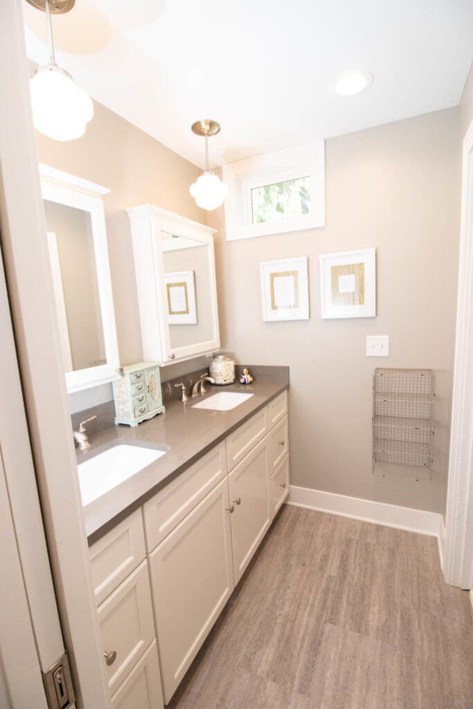 double sink vanity by Odd Fellows Contracting in East Lansing MI with white cabinets and modern lighting