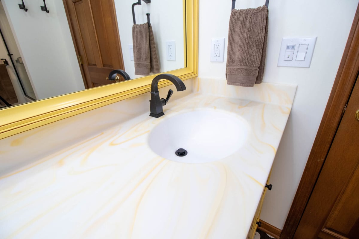 bathroom vanity detail by Odd Fellows Contracting in Okemos MI with integrated sink and matte black faucet