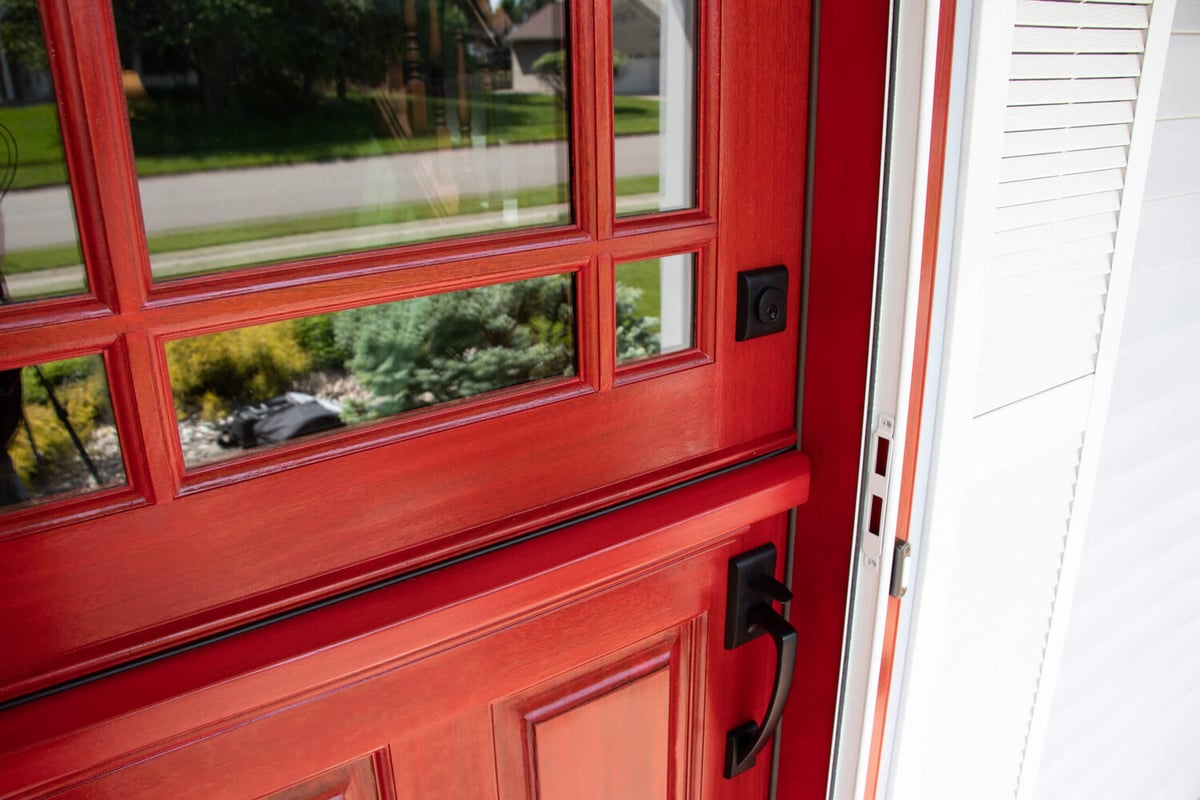 front door detail by Odd Fellows Contracting in Okemos MI with glass panels and black hardware
