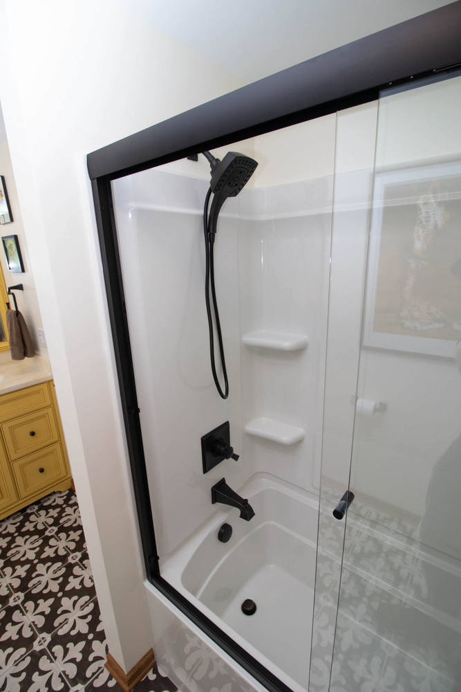 shower detail by Odd Fellows Contracting in Okemos MI with glass enclosure and black fixtures