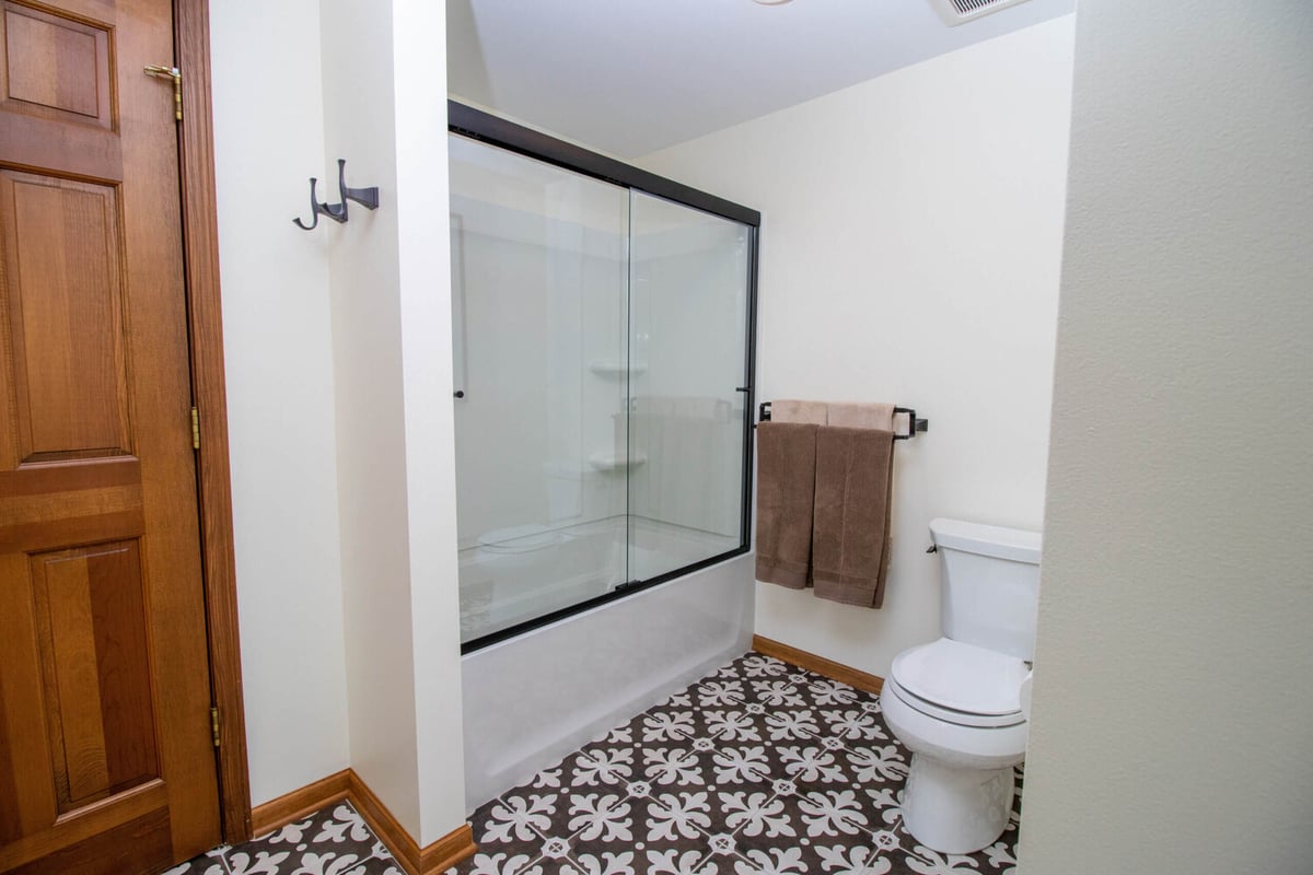 updated bathroom by Odd Fellows Contracting in Okemos MI featuring modern shower fixtures and tile floor
