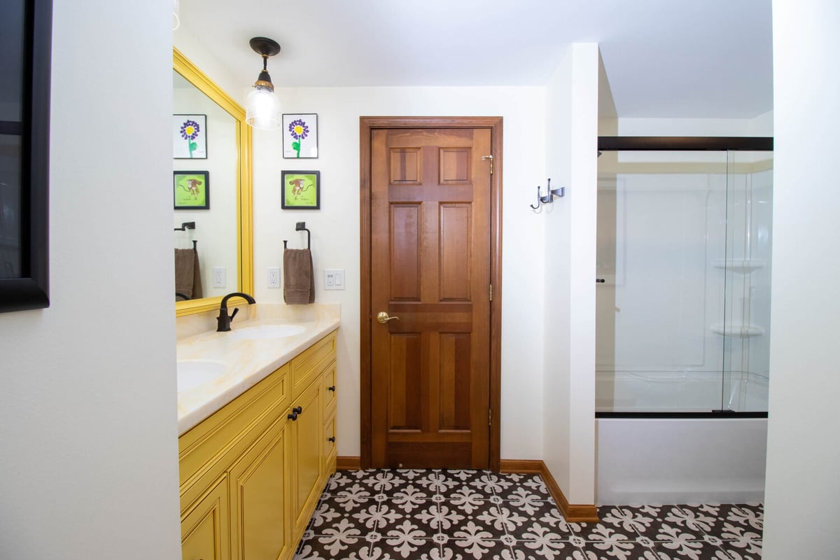 updated bathroom layout by Odd Fellows Contracting in Okemos MI featuring vanity and glass shower doors