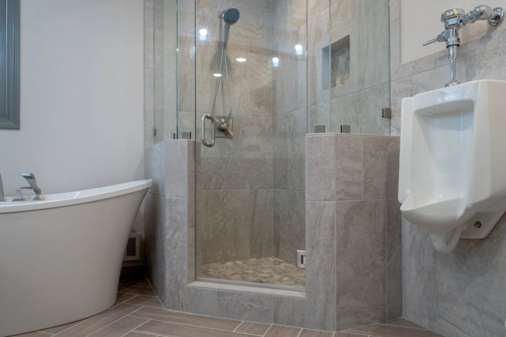 bathroom renovation featuring walk in glass shower and modern soaking tub by Odd Fellows Contracting in Okemos MI