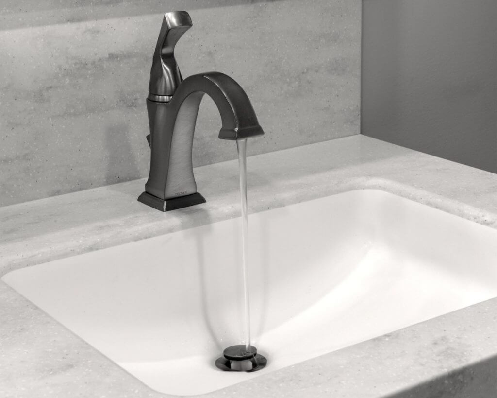 close up of bathroom vanity faucet and quartz countertop by Odd Fellows Contracting in Okemos MI