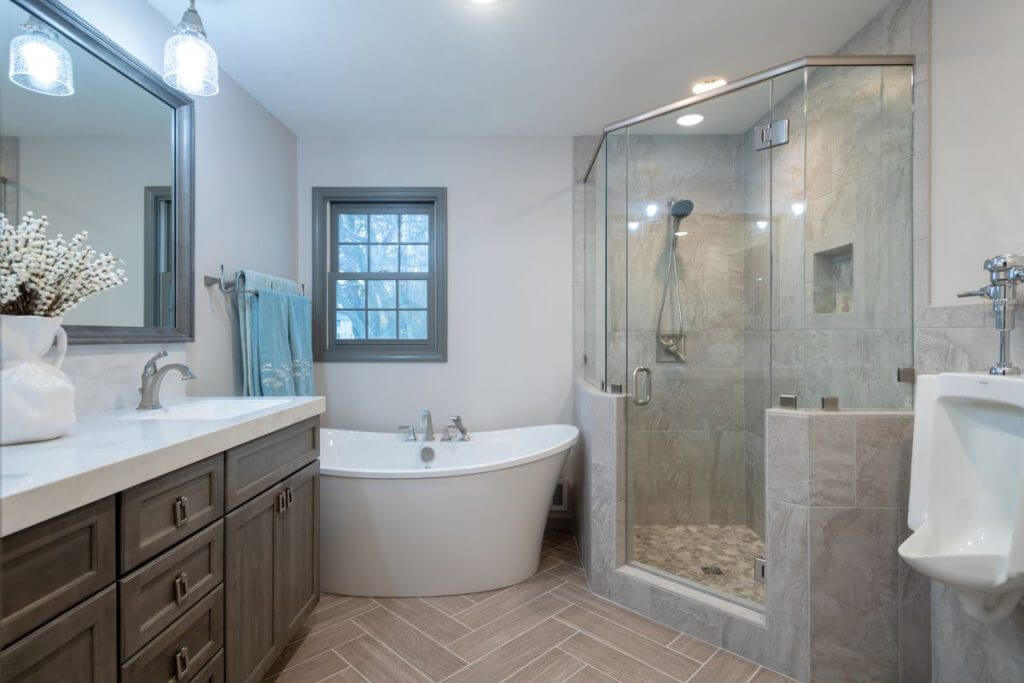luxury bathroom renovation with quartz vanity and glass shower by Odd Fellows Contracting in Okemos, MI