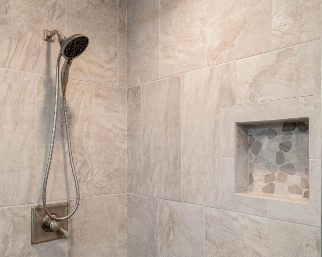 tiled walk in shower with recessed niche and brushed nickel fixtures by Odd Fellows Contracting in Okemos MI