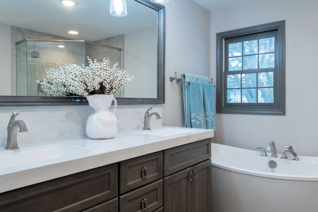 updated bathroom vanity area with modern fixtures by Odd Fellows Contracting in Okemos, MI