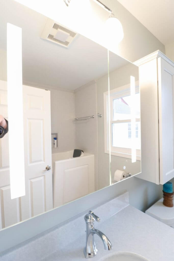 bathroom remodel by Odd Fellows Contracting in Williamston, MI with illuminated mirror and modern vanity