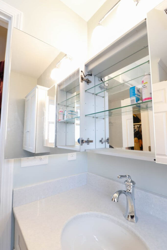 custom bathroom remodel by Odd Fellows Contracting in Williamston, MI with mirrored medicine cabinet and quartz countertop