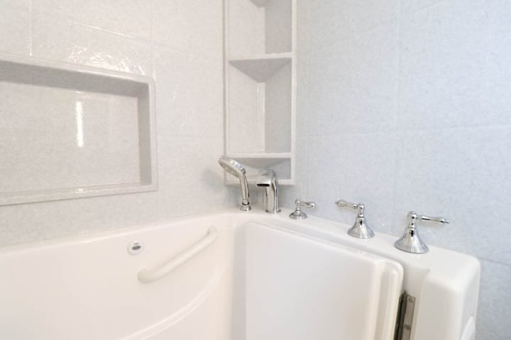 detailed walk-in tub remodel by Odd Fellows Contracting in Williamston, MI with built-in niche and shelving