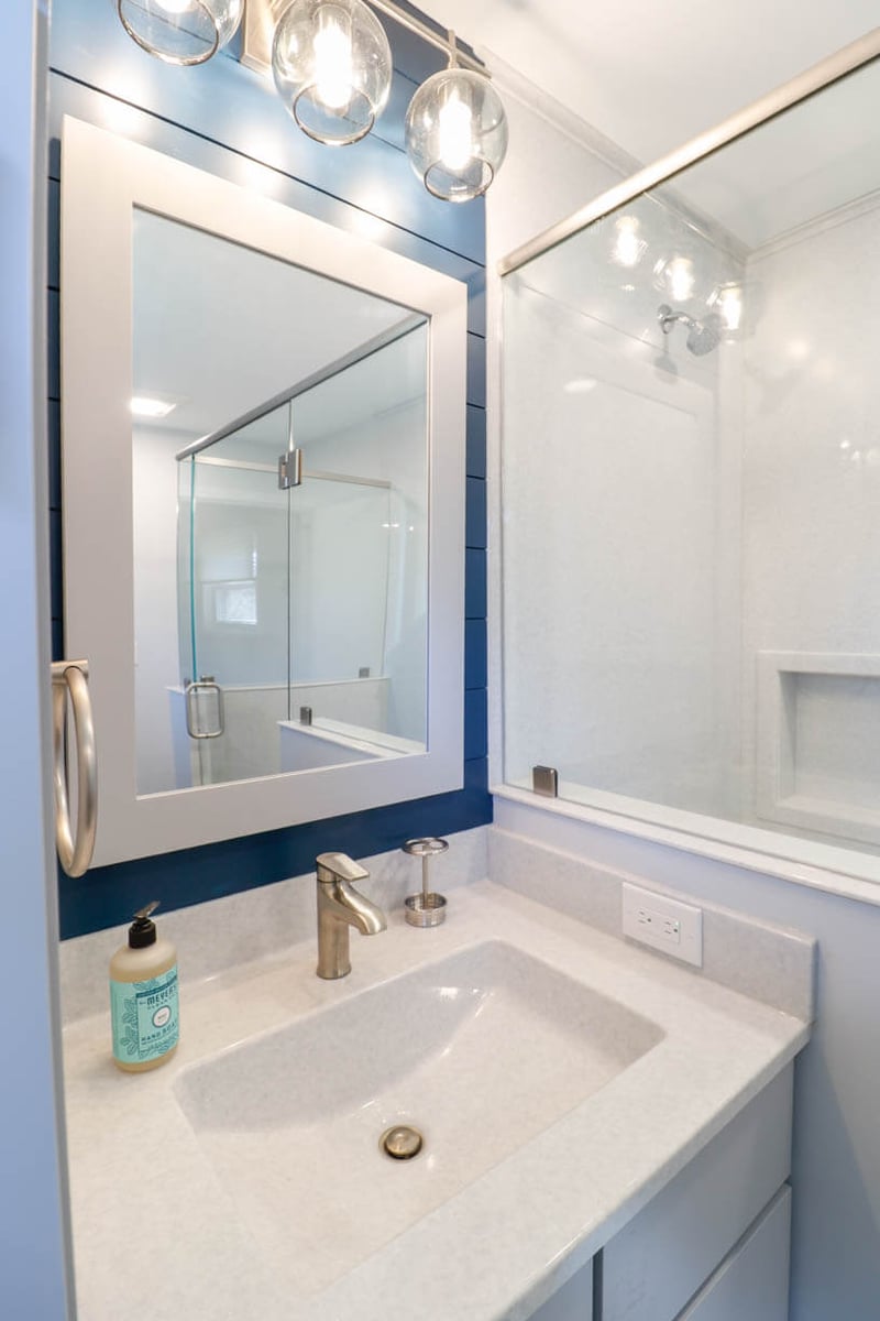 modern vanity installation by Odd Fellows Contracting in Briarwood Okemos, MI with updated mirror and lighting