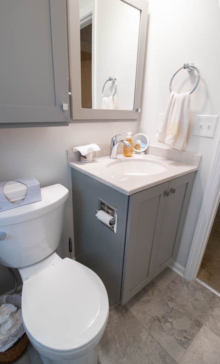 compact bathroom renovation by Odd Fellows Contracting in Mulliken, MI featuring new toilet, vanity, and easy-care flooring