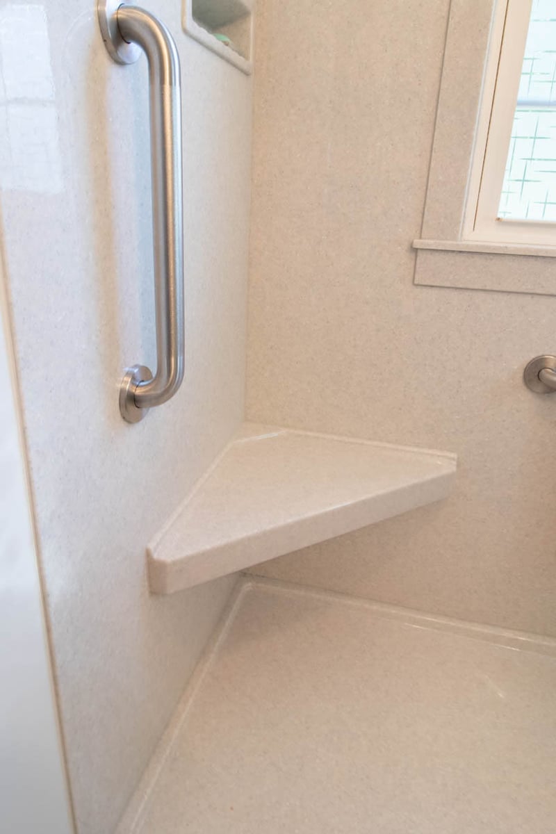 updated vanity area from bathroom remodel by Odd Fellows Contracting in Mulliken, MI with gray cabinet and solid surface countertop