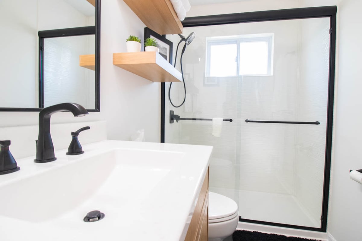 Holt, MI bathroom remodel by Odd Fellows Contracting featuring quartz vanity and framed mirror
