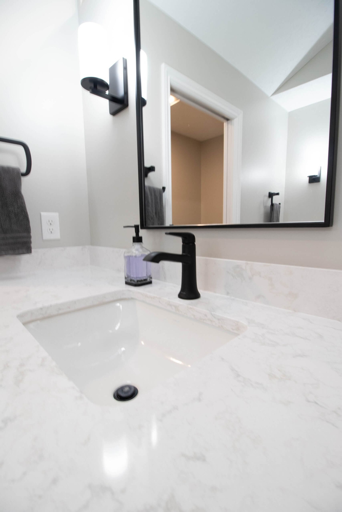 close-up of quartz vanity and matte black faucet from bathroom remodel by Odd Fellows Contracting in Portland, MI