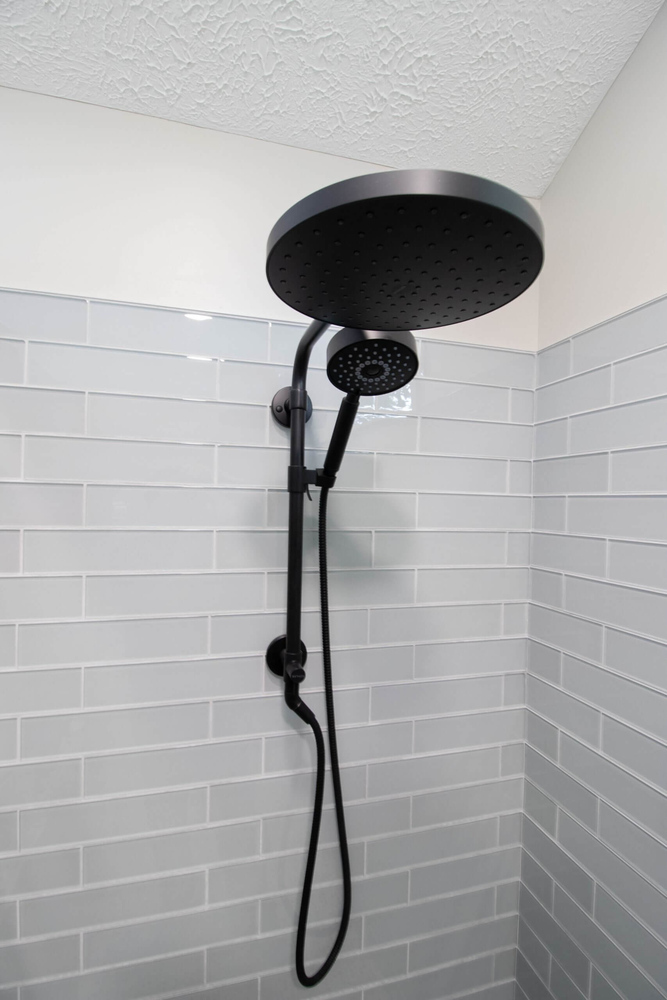 rainfall showerhead detail from bathroom remodel by Odd Fellows Contracting in Portland, MI with gray tile surround