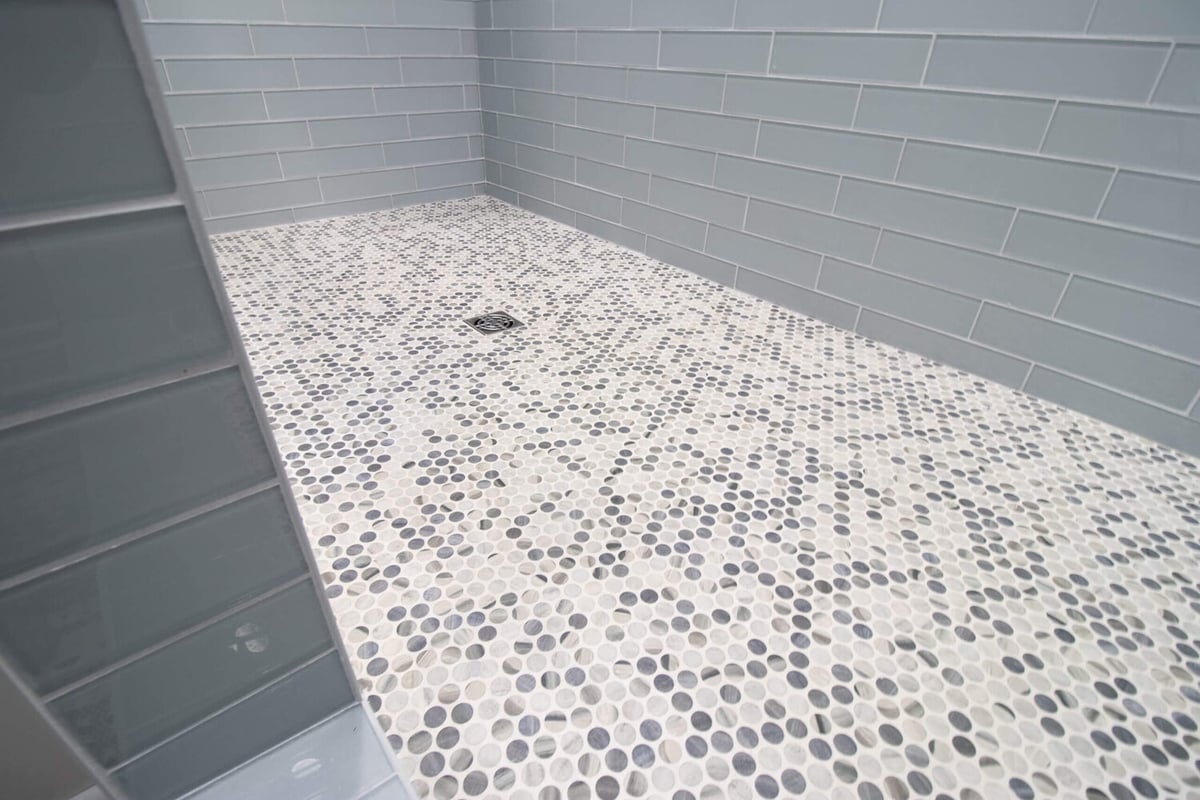 tiled walk-in shower floor from bathroom remodel by Odd Fellows Contracting in Portland, MI with pebble mosaic tile