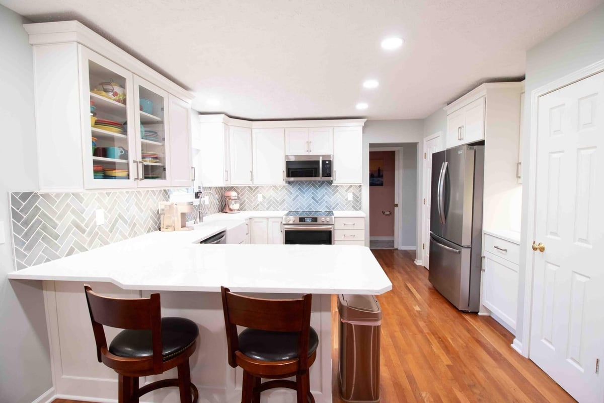 Kitchen remodel with white cabinets and quartz countertops by Odd Fellows Contracting in Mason, MI