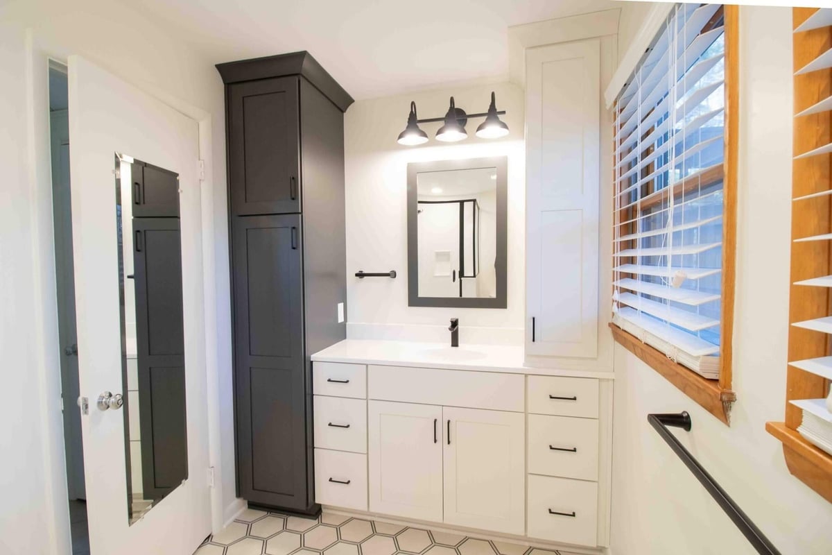 remodeled bathroom vanity with white cabinetry quartz countertop and black hardware by Odd Fellows Contracting in Okemos MI