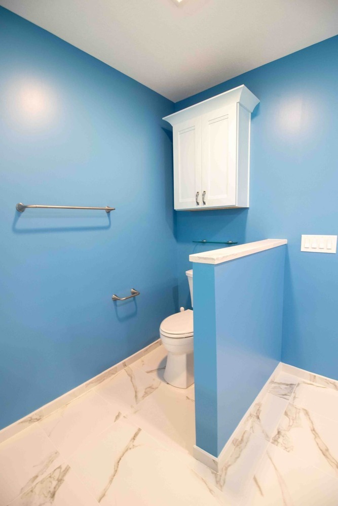 remodeled bathroom with custom vanity cabinets and blue accent walls by Odd Fellows Contracting in Okemos MI