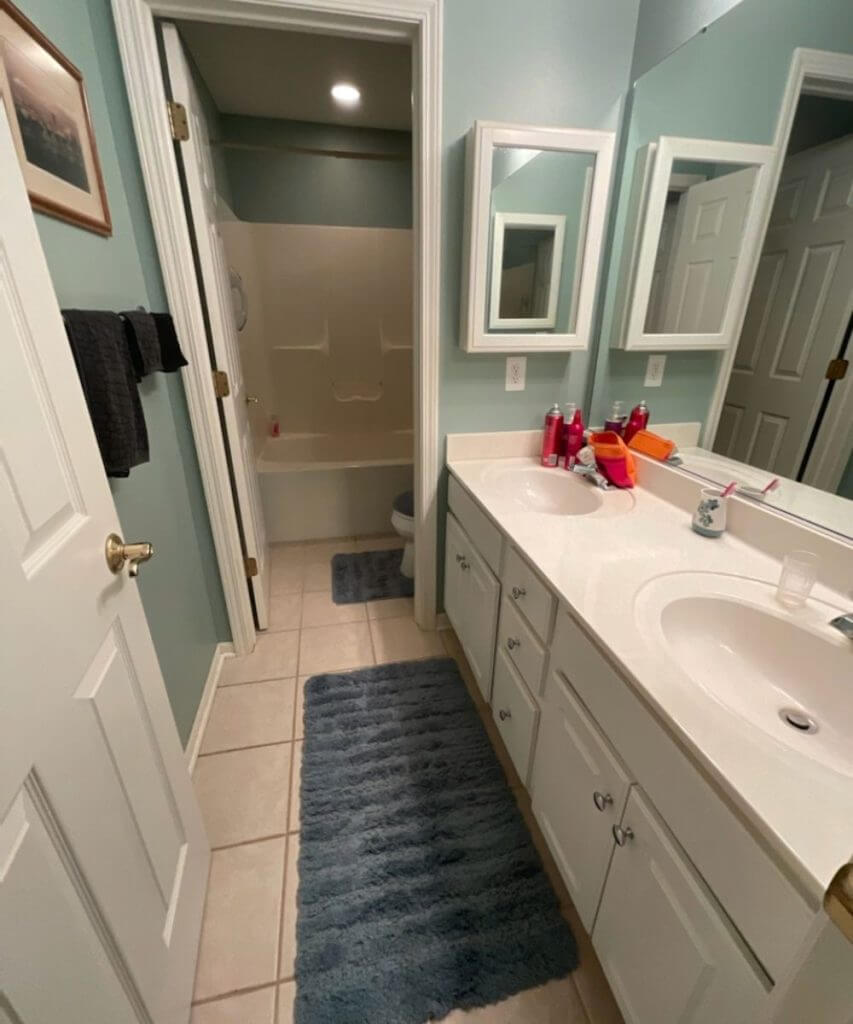 bathroom before remodel with original vanity cabinets and tub shower by Odd Fellows Contracting in East Lansing MI
