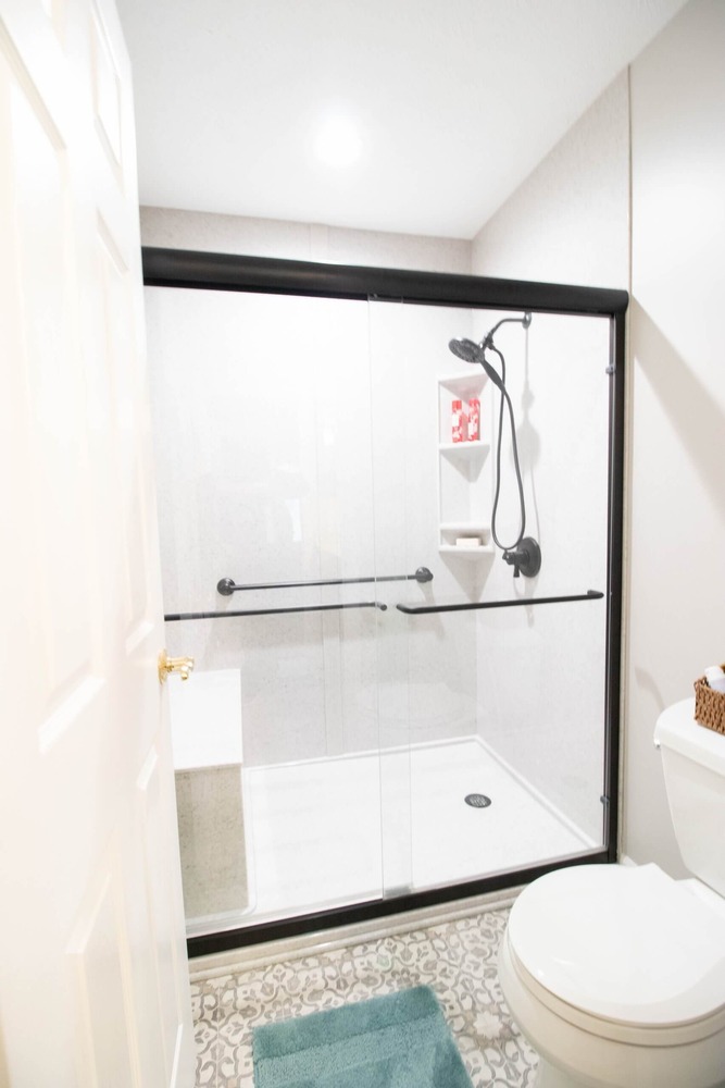 bathroom remodel featuring modern shower surround and sliding glass doors by Odd Fellows Contracting in East Lansing MI