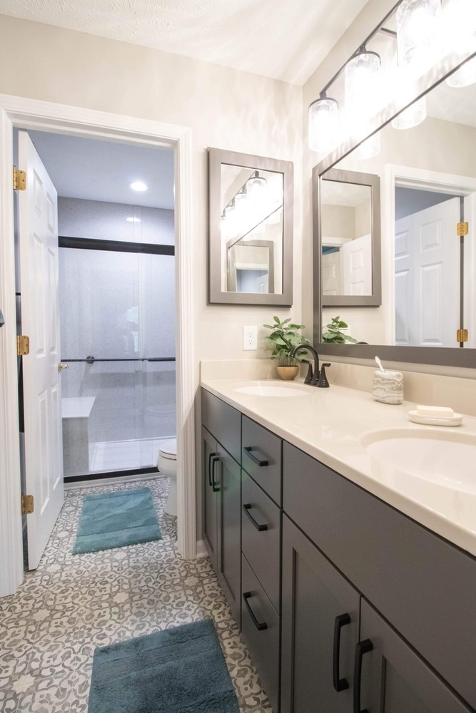 remodeled bathroom vanity with gray cabinets and double sink countertop by Odd Fellows Contracting in East Lansing MI
