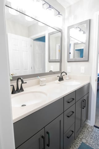 renovated bathroom vanity area with gray cabinets and updated lighting by Odd Fellows Contracting in East Lansing MI