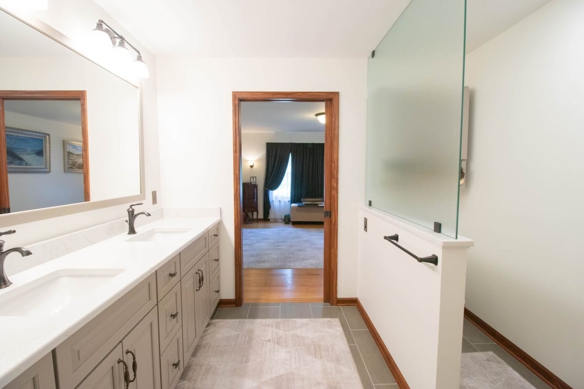 bathroom renovation featuring custom vanity cabinets large mirror and updated fixtures by Odd Fellows Contracting in DeWitt MI