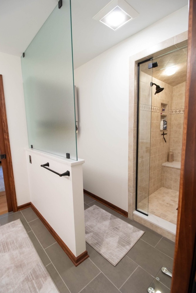 remodeled walk in shower with glass enclosure and tiled walls by Odd Fellows Contracting in DeWitt MI
