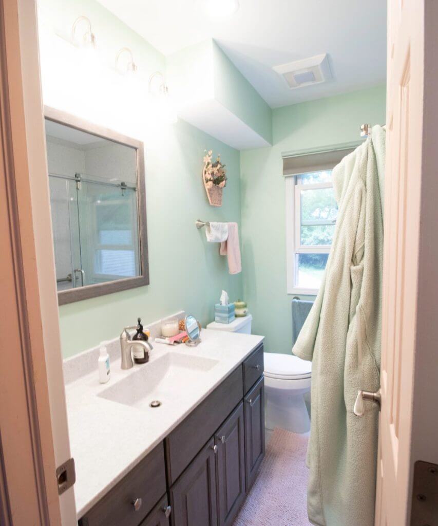 finished bathroom renovation with gray vanity and modern fixtures by Odd Fellows Contracting in Williamston MI