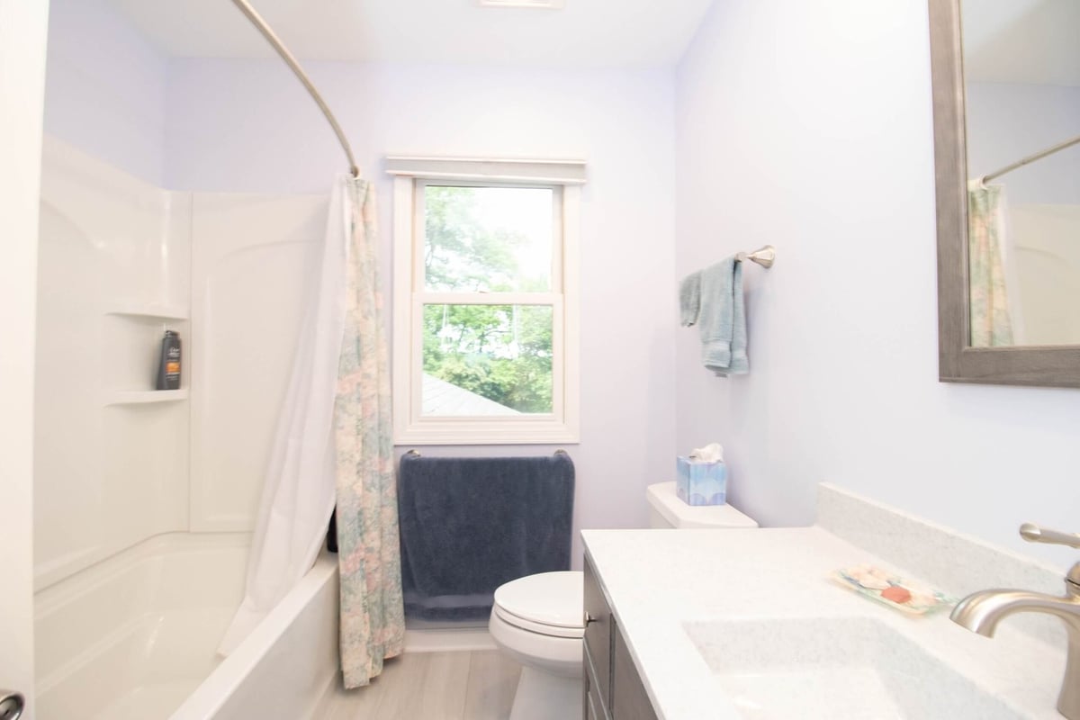 remodeled bathroom vanity with quartz countertop and modern fixtures by Odd Fellows Contracting in Williamston MI