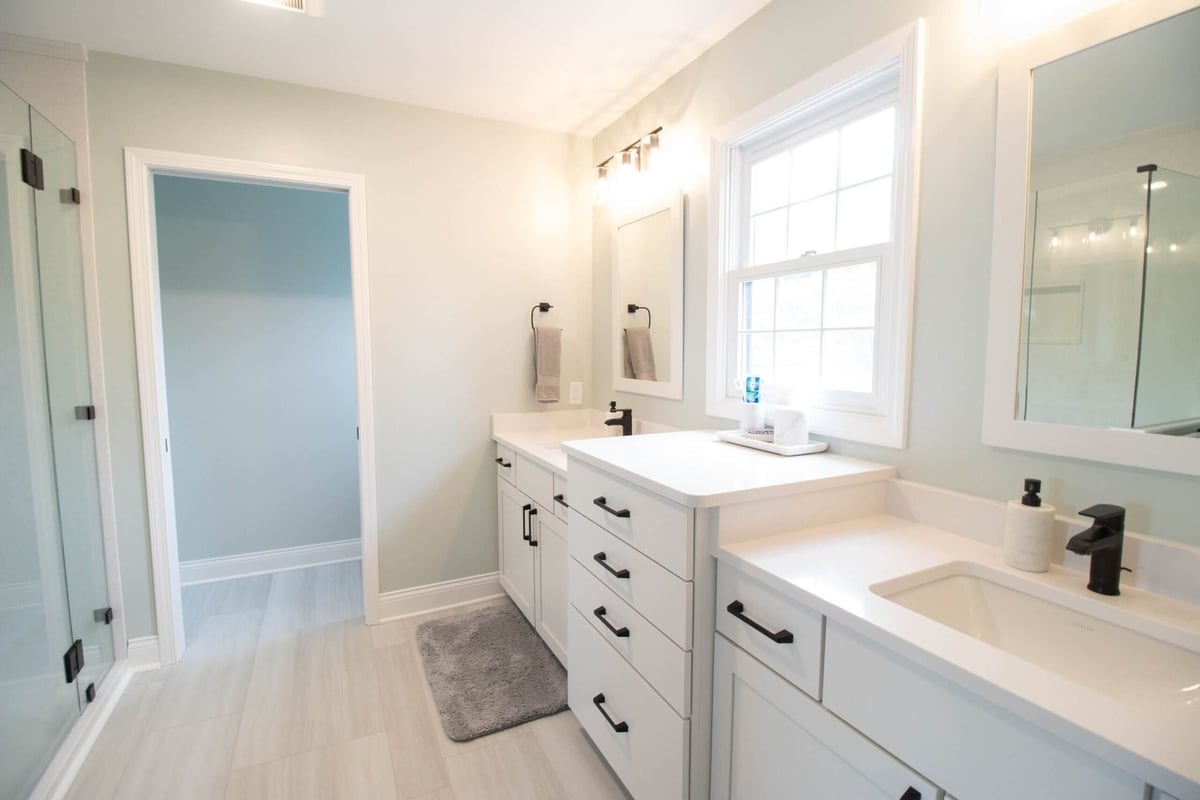 bathroom renovation featuring white shaker vanity cabinets and updated mirrors by Odd Fellows Contracting in Holt MI