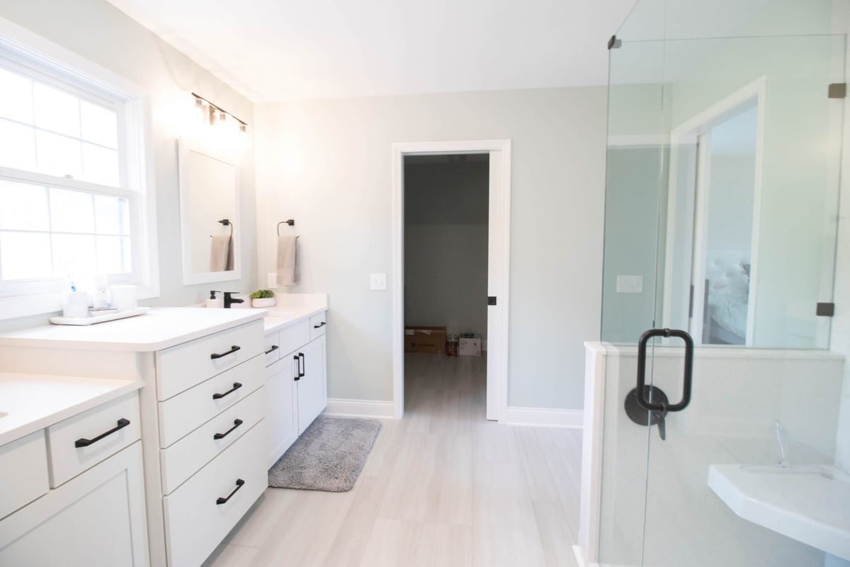 remodeled bathroom shower with glass enclosure and corner bench by Odd Fellows Contracting in Holt MI