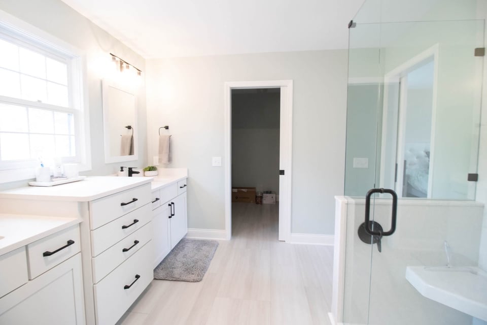 remodeled bathroom shower with glass enclosure and corner bench by Odd Fellows Contracting in Holt MI