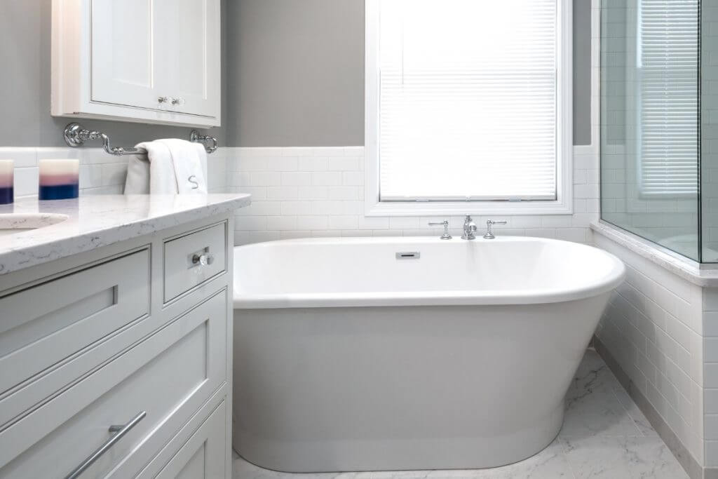Spacious master bathroom with tub and walk-in shower by Odd Fellows Contracting in Williamston, MI