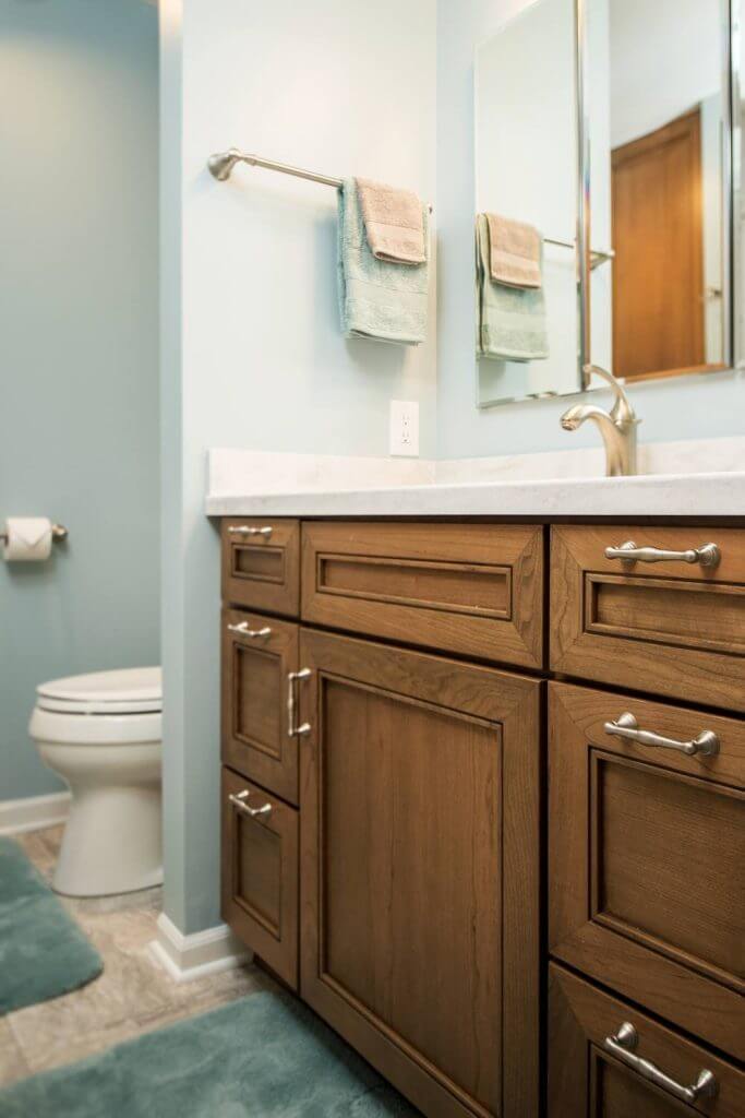 Bathroom vanity with wood cabinetry and marble countertop installed by Odd Fellows Contracting in Holt, MI