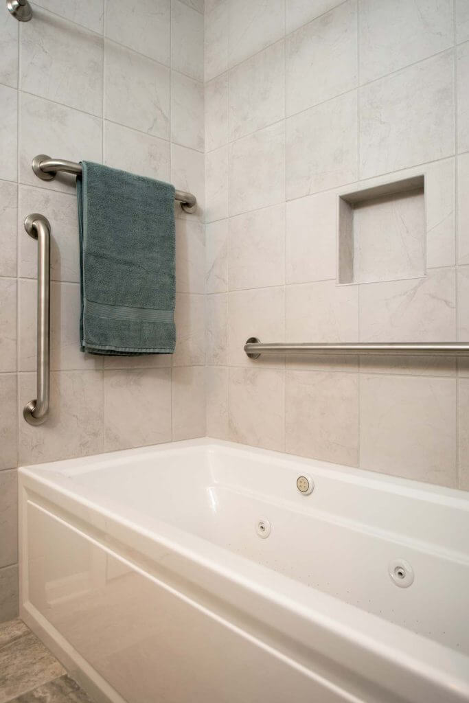 Bathtub with tile surround and safety grab bars installed by Odd Fellows Contracting in Holt, MI bathroom renovation