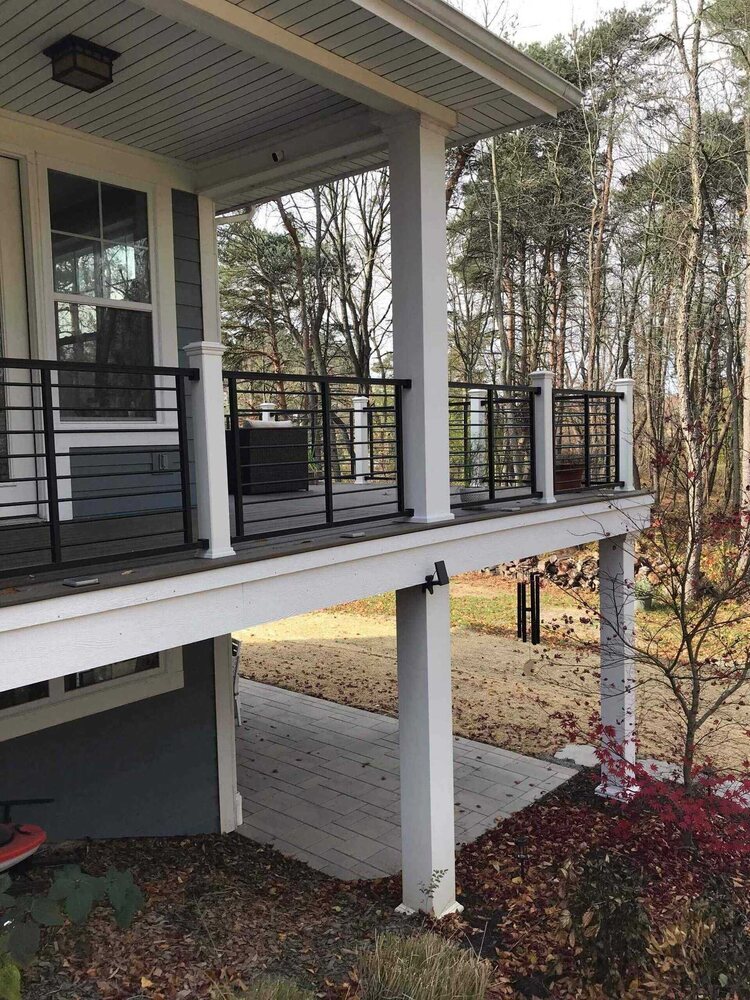 finished outdoor deck with covered patio below by Odd Fellows Contracting in Lansing, MI