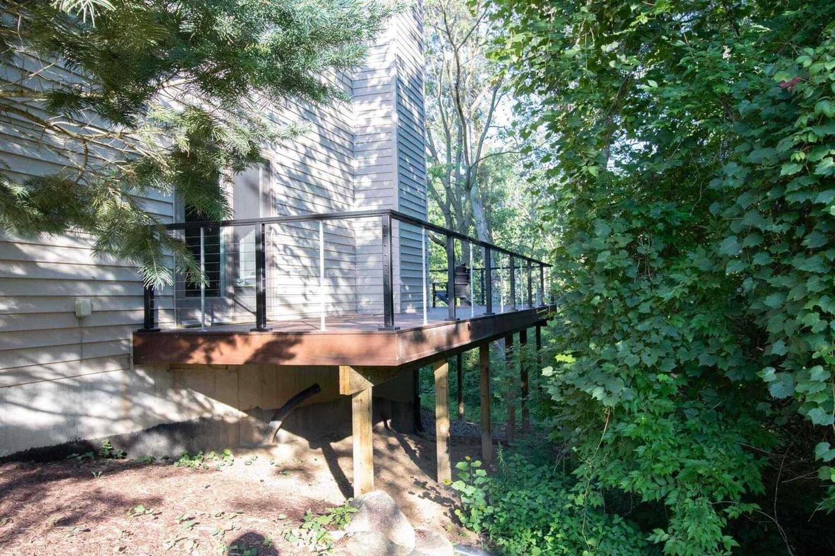 finished composite deck with cable railing system by Odd Fellows Contracting in Haslett, MI