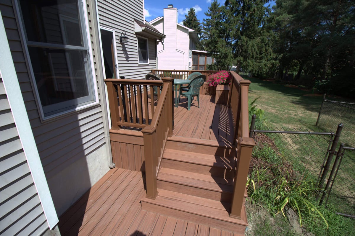 Backyard composite deck with outdoor dining table installed by Odd Fellows Contracting in Haslett, MI