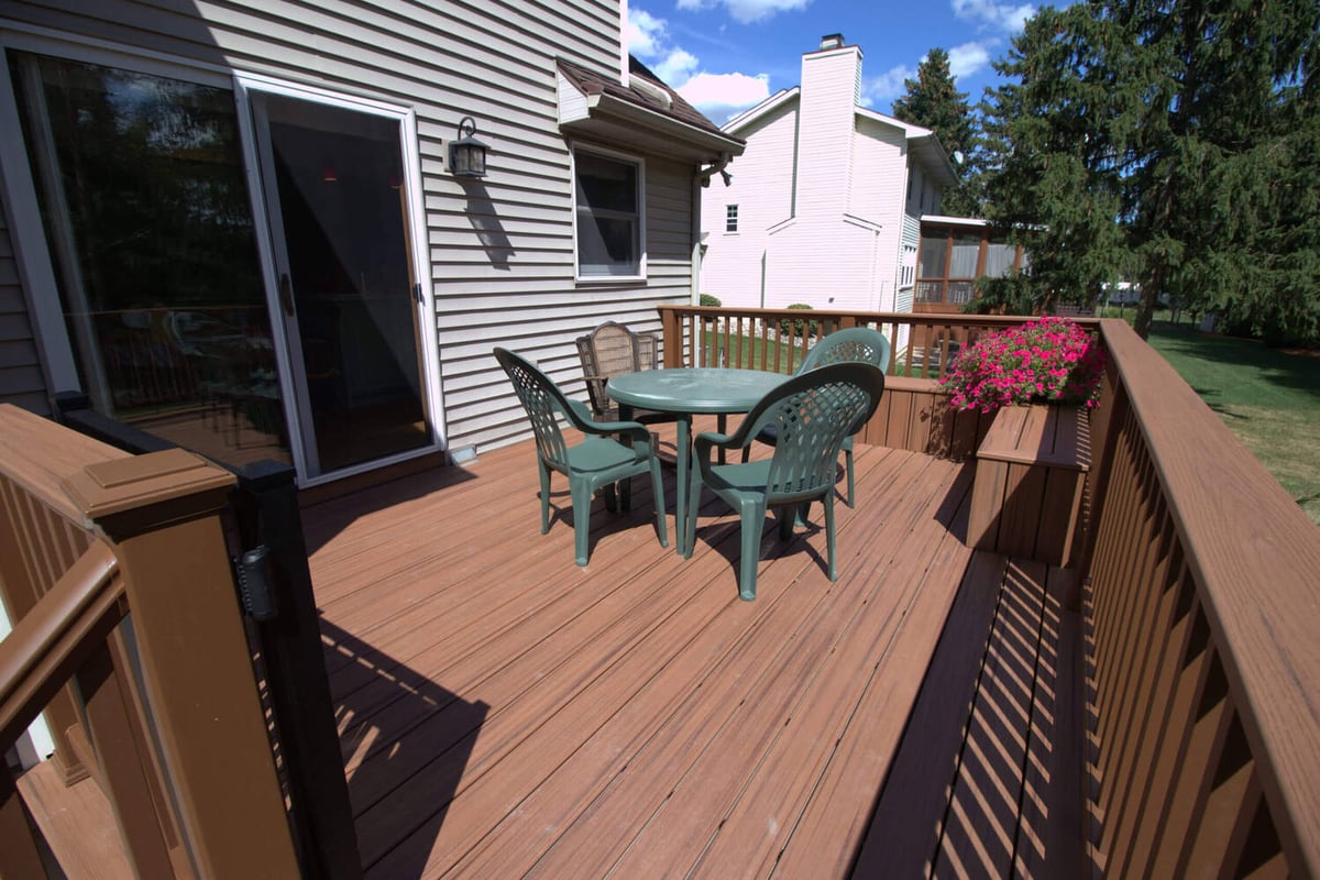Composite deck remodel with outdoor seating area by Odd Fellows Contracting in Haslett, MI
